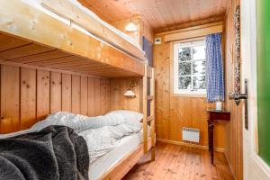 a bedroom with a bunk bed in a wooden cabin at Cottage right next to cross country tracks in Ringsaker