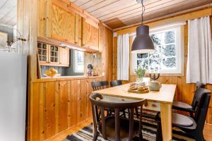 a kitchen and dining room with a wooden table and chairs at Cottage right next to cross country tracks in Ringsaker