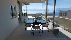 a table and chairs on a balcony with a view of the ocean at attico sottovento in Reggio di Calabria