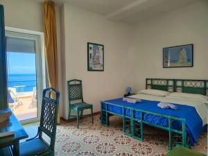 1 dormitorio con cama, mesa y ventana en Hotel Phenicusa, en Filicudi