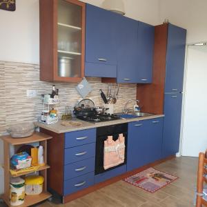 una cocina con armarios azules y fregadero en villetta immersa nell'agrumeto en Noto Marina