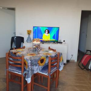 einen Tisch und Stühle mit einem TV im Zimmer in der Unterkunft villetta immersa nell'agrumeto in Noto Marina