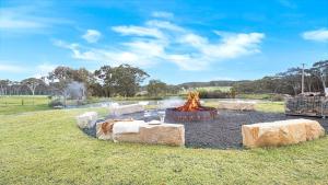 a fire pit in the middle of a field at Sutton Forest Retreat The Hideaway in Sutton Forest