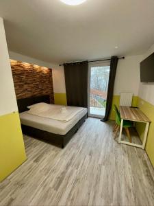 Schlafzimmer mit einem Bett, einem Fenster und einem Tisch in der Unterkunft Silvio-Gesell-Tagungsstätte in Wuppertal