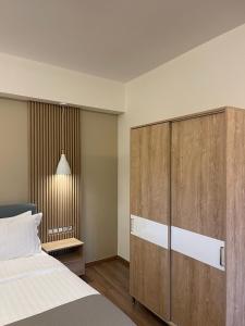 1 dormitorio con 1 cama y un gran armario de madera en 11 Luxury Apartments.., en Metsovo