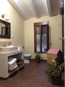 een badkamer met een wastafel, een toilet en een spiegel bij Vivienda Rural Embalse San Clemente in Huéscar