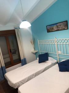 two beds in a room with blue walls at Vivienda Rural Embalse San Clemente in Huéscar