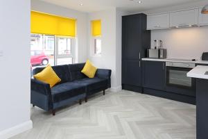 a living room with a blue couch in a kitchen at No1 Luxury Service Apartments in Belfast
