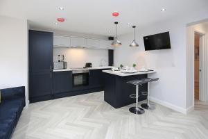 a kitchen with blue cabinets and a counter top at No1 Luxury Service Apartments in Belfast