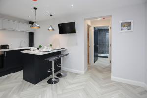 a kitchen with a counter and a bar with a stool at No1 Luxury Service Apartments in Belfast +30 photos
