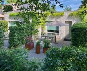 a courtyard with a bench and an umbrella at Marcel de Gand Business & Travel in Ghent