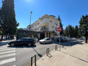 un estacionamiento con autos estacionados frente a un edificio en Green Hills II by Rent a car MI en Podgorica