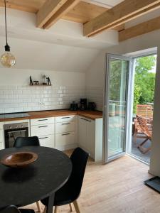 a kitchen with a table and chairs and a patio at Klein Westerland OG in Brodersby