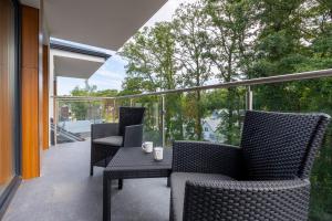 a patio with two chairs and a table on a balcony at Little Laguna Apartments Sauna & Parking by Renters in Międzywodzie