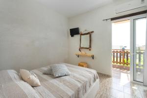 a bedroom with a bed and a large window at Christos studios and family apartments in Rhodes Town
