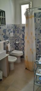 a bathroom with a toilet and a shower curtain at Casa Poesia in Torre dell'Orso