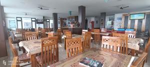 a dining room with wooden tables and chairs at HOTEL DEVDAR RESORT in Dharmsāla +42 photos