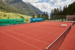 una pista de tenis con un banco blanco en Almandin Apartments, en Ischgl