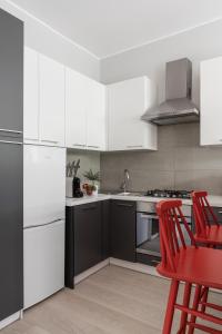 kuchnia z białymi urządzeniami i czerwonymi krzesłami w obiekcie Sanhaus Apartments - PLAYA 2 - Apartament przy samej plaży w mieście Sopot