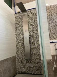 a shower in a bathroom with a tile wall at HOMESTAY D' SEPANGAR HILLS in Kota Kinabalu
