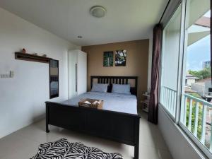 ein Schlafzimmer mit einem Bett und einem großen Fenster in der Unterkunft Boxsoon Nimman 4 in Chiang Mai