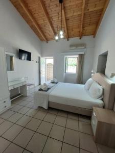 a large bedroom with a large bed and a window at Electra Villa & Pool Studios in Gaios