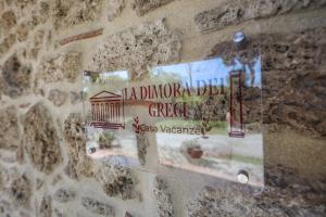 un muro con un cartello su un muro di pietra di Dimora dei Greci a Paestum