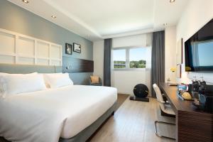 a hotel room with a bed and a desk and a television at voco Venice Mestre - The Quid, an IHG Hotel in Mestre