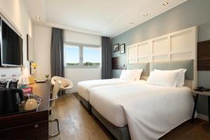 Cette chambre comprend deux lits et une télévision. dans l'établissement voco Venice Mestre - The Quid, an IHG Hotel, à Mestre
