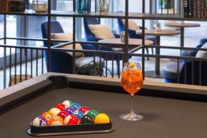 ein Getränk und ein Tablett mit Poolbällchen und einem Glas in der Unterkunft voco Venice Mestre - The Quid, an IHG Hotel in Mestre