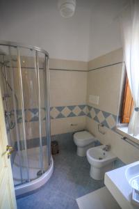 a bathroom with a shower and a toilet and a sink at Dimora dei Greci in Paestum