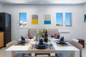 a dining room with a white table and chairs at Residence Luce del Mare in San Vito lo Capo