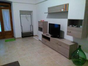 a living room with a flat screen tv on a wooden entertainment center at DonVito Casa Vacanze in Alberobello +13 photos