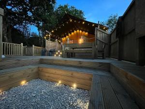 a deck with a bench and lights on it at Robin Hood Safari Tent in Tenby