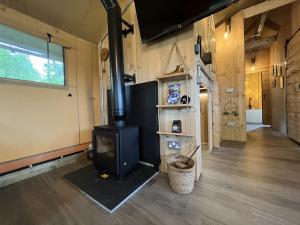 a living room with a wood stove in a tiny house at Robin Hood Safari Tent in Tenby