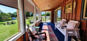 un porche de una casa con sillas y ventanas en Buln Buln Cabins, en Yanakie