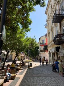 una calle en una ciudad con gente sentada en bancos en 113 in Sofia with 2BR and 2 full bath, en Sofía