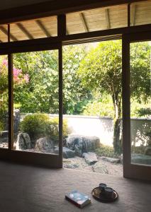 a view of a garden through a glass door at Akizuki Gallery House in Asakura