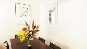 Akizuki Gallery House في Asakura: غرفة طعام مع طاولة مع إناء من الزهور