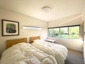 a bedroom with two beds and a window at Akizuki Gallery House in Asakura