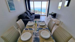 a dining room with a table and chairs with a view of the ocean at Increibles vistas al mar desde la terraza privada en la planta 39 in Benidorm