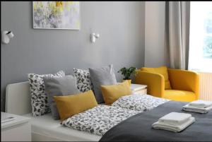 ein Schlafzimmer mit einem Bett und zwei gelben Stühlen in der Unterkunft 3bdr/2bath/3A/c design apt, central, free parking, quiet in Budapest