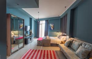 a bedroom with a couch and a bed and a mirror at Boulevardside in Batumi +108 photos
