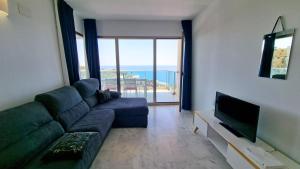 a living room with a couch and a flat screen tv at Increibles vistas al mar desde la terraza privada en la planta 39 in Benidorm