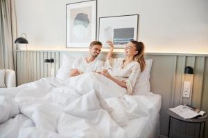 a man and a woman sitting in bed at Bluesun Hotel Borak in Bol