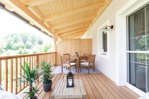 un patio con mesa y sillas en una terraza de madera en Ferienwohnungen in der alten Schnapsbrennerei Kolleritsch in Mureck, en Mureck