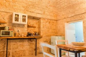 a kitchen with a wooden table and a table and chairs at La Casedda - Apartment & Hydromassage in Ceglie Messapica
