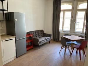 a living room with a table and a chair and a refrigerator at Žižkov tower suites in Prague