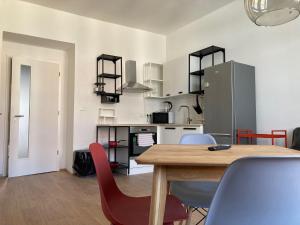 布拉格的住宿－Žižkov tower suites，厨房以及带木桌和椅子的用餐室。