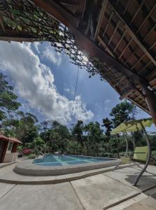 a view of a swimming pool with an umbrella at VILLA OPA DOEL YOGYAKARTA in Yogyakarta